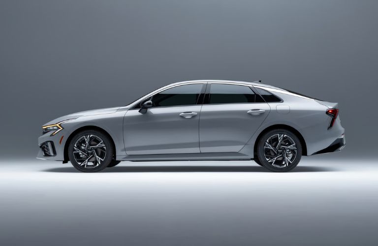 2025 Kia K5 side view in a gray room